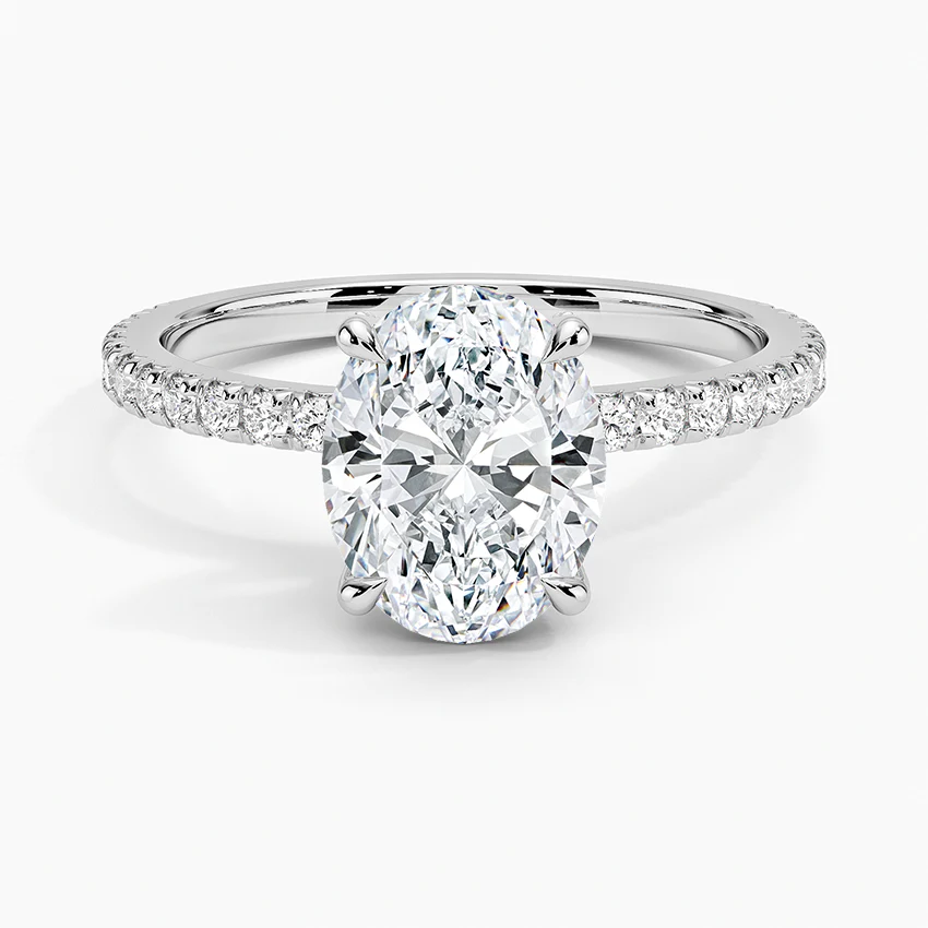 Oval diamond engagement ring with pave-set side stones in white gold.