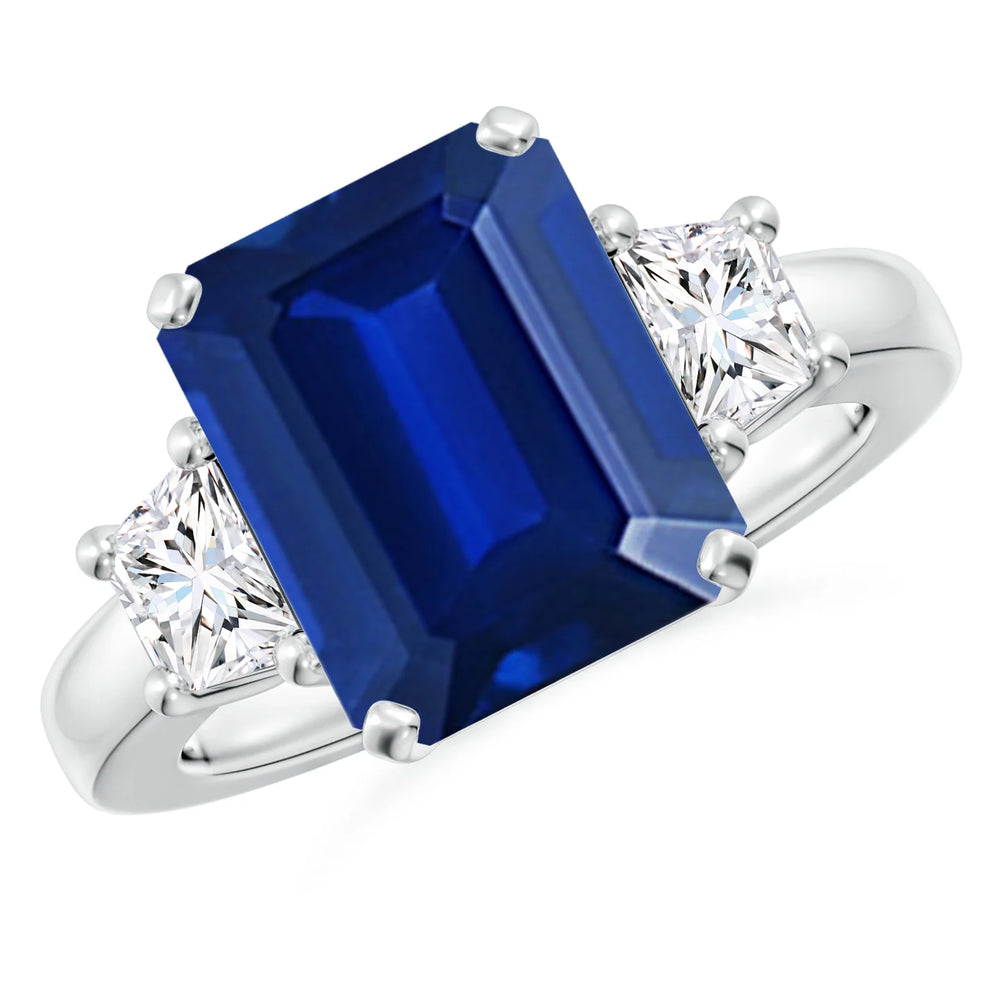 Emerald-cut blue sapphire three stone ring in 14K white gold by Irdoja Diamonds.