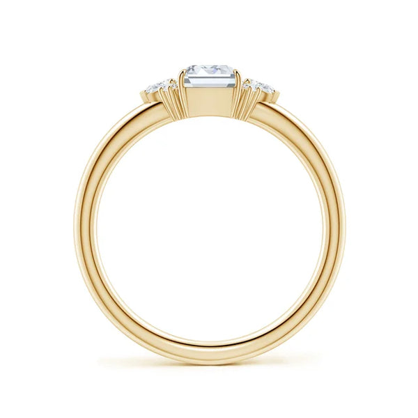 Four-claw prong emerald-cut lab-grown diamond engagement ring in 18k yellow gold with marquise diamond accents.