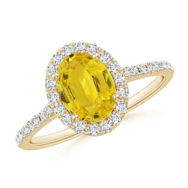 Prong-set oval yellow sapphire halo ring with diamond accents in 14k gold by Irdoja Diamonds.