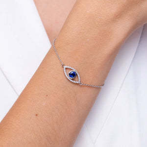 Bezel-Set Sapphire & Diamond Evil Eye Bracelet worn on wrist, featuring a blue sapphire and diamond halo.
