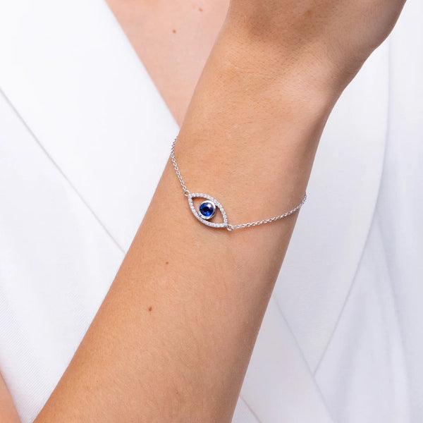 Bezel-Set Sapphire & Diamond Evil Eye Bracelet displayed on a wrist, showcasing its blue sapphire and diamond halo design.