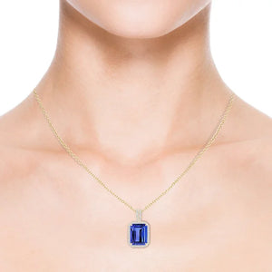 3.4ct Emerald-Cut Tanzanite Halo Pendant 18K Gold AAA Quality displayed on a model's neck, showcasing vivid blue-violet color.