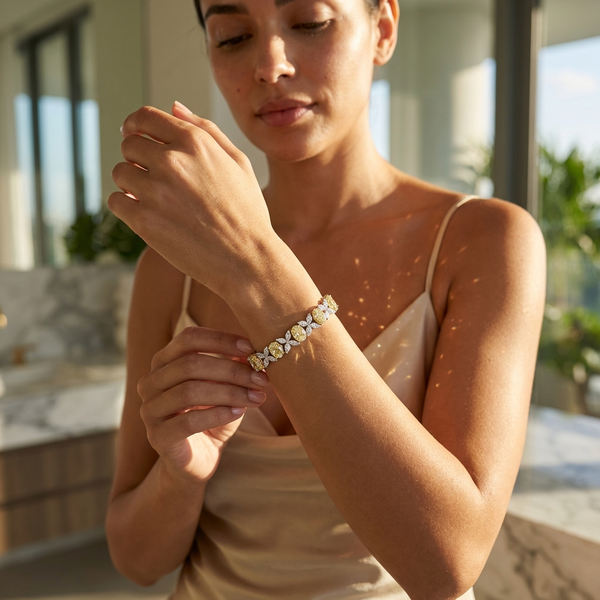 Woman showcasing a Fancy Yellow & White Lab Diamond Bracelet under sunlight, highlighting its elegance and sparkle.