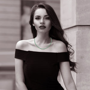 Hexagon Emerald Tennis Necklace - 14K/18K Gold Bezel Set worn by a model, showcasing vibrant green emeralds against a black dress.
