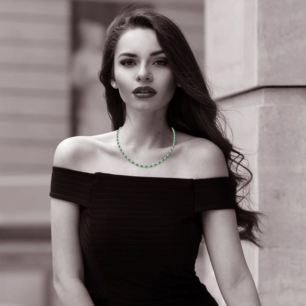 Hexagon Emerald Tennis Necklace - 14K/18K Gold Bezel Set worn by a model, showcasing vibrant green emeralds against a black dress.