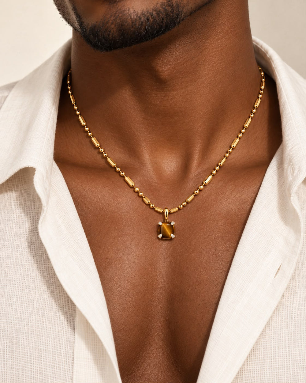 Bloom amulet necklace, a tiger's eye pendant on a 14K yellow gold ball-and-bar chain