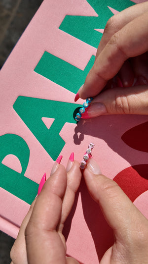 An Irdoja Bubble band in teal enamel held between two hands in daylight.