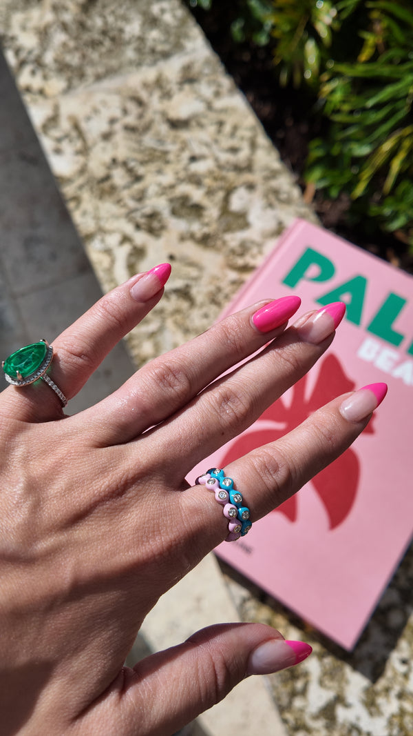 Irdoja Bubble bands stacked on a hand beside an emerald ring, showing how wide the band sits on the finger.