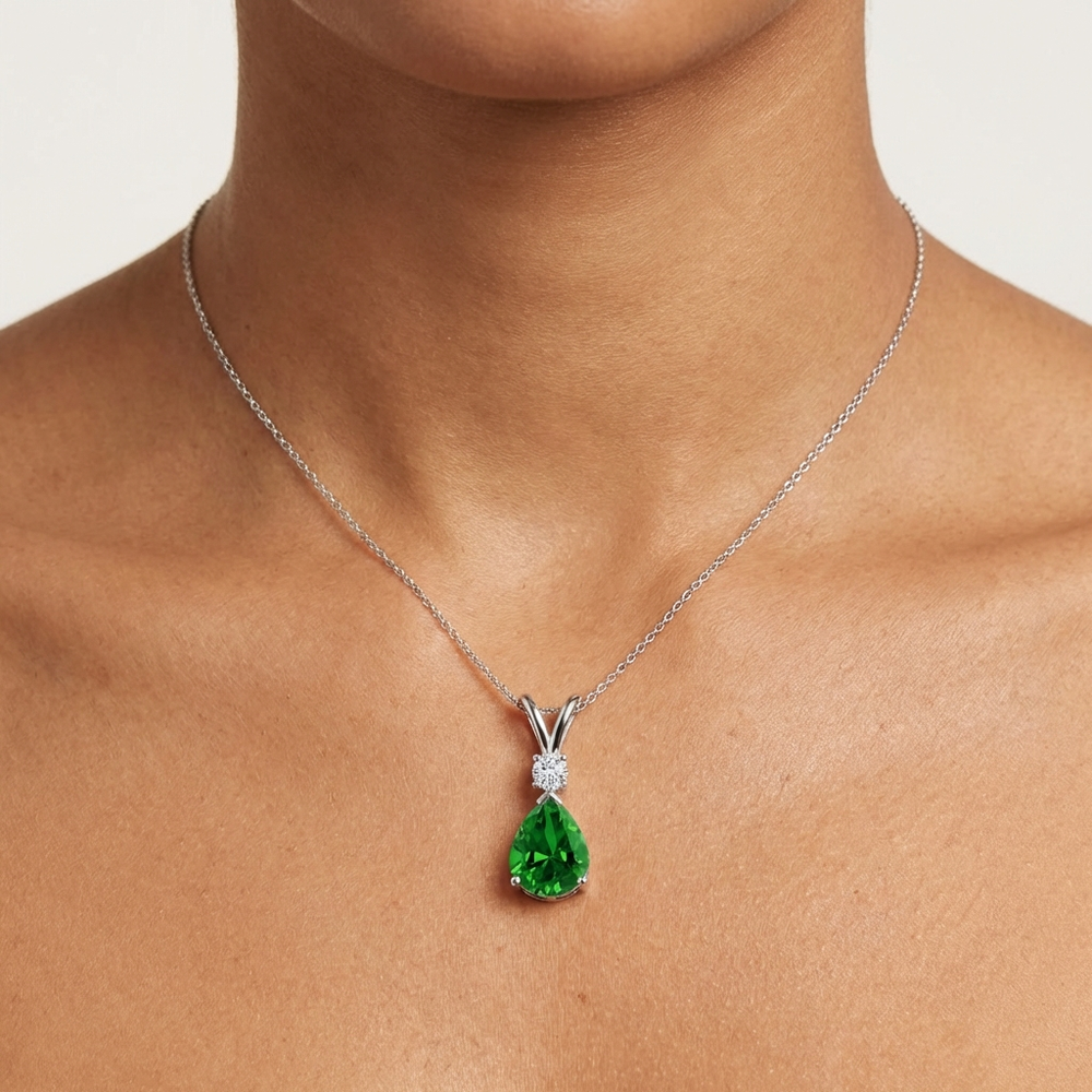 Prong-Set Lab-Grown Emerald Teardrop V-Bale Pendant with Diamond showcased on a model's neck.