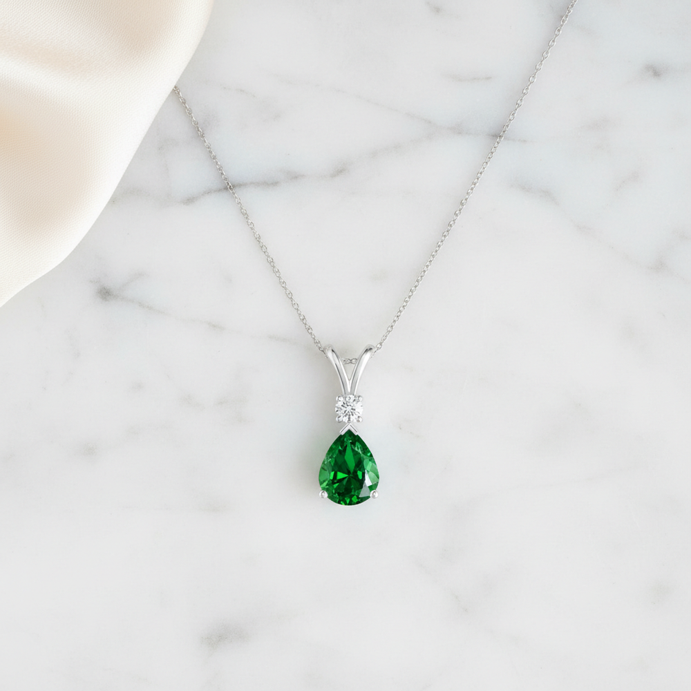 Prong-Set Lab-Grown Emerald Teardrop V-Bale Pendant with Diamond showcased on a model's neck.